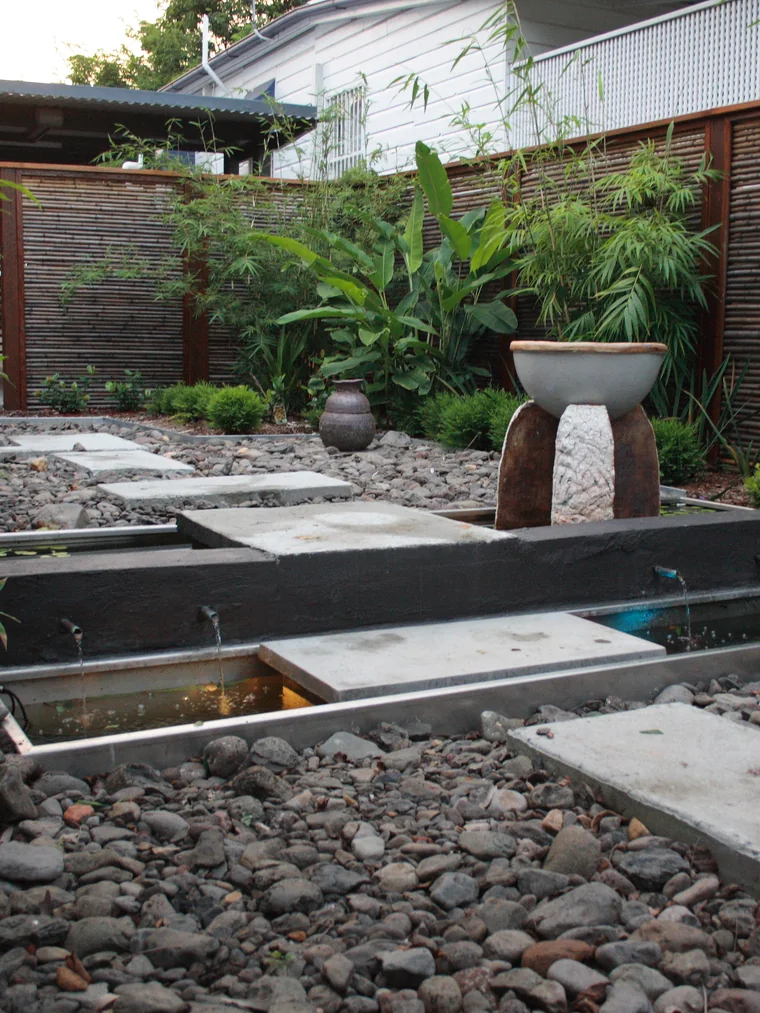 Timber-framed bamboo screens enclosing a courtyard of water rills, stepping slabs and river stone